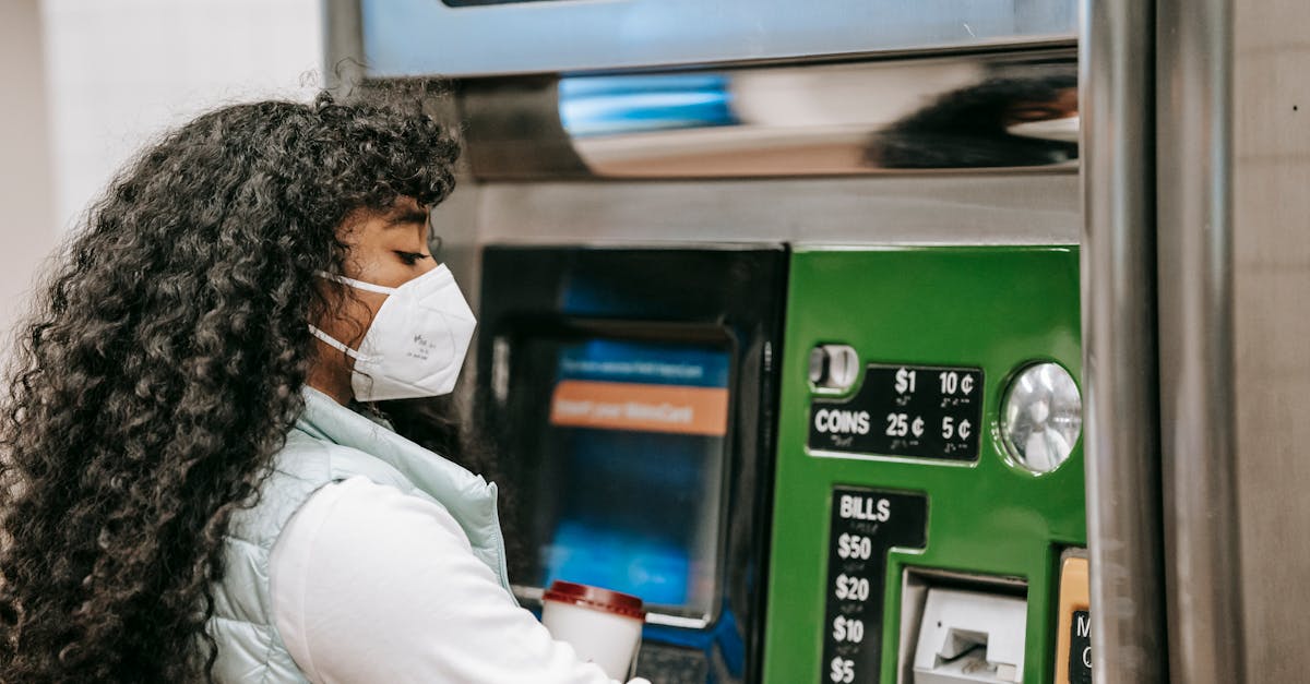 a-woman-wearing-a-face-mask-uses-a-ticket-machine-for-purchasing-fare-in-a-public-setting-reflectin